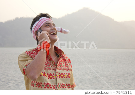 Bihu man talking on a mobile phone Bihu man talking on a mobile phone 7941511