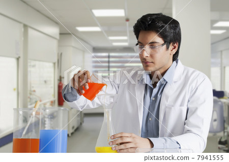 Young scientist pouring solution in a flask 7941555