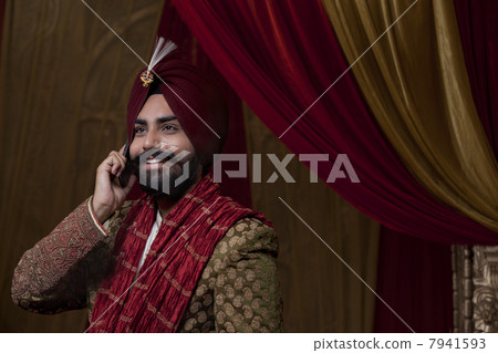 Close-up of groom having conversation on mobile phone 7941593