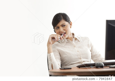 Businesswoman on call while looking at computer Businesswoman on call while looking at computer 7941647