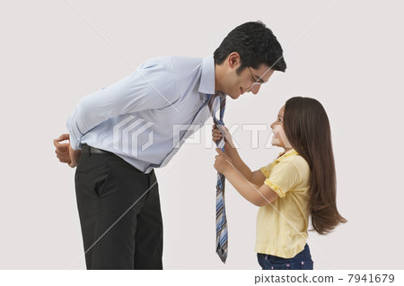 Young girl adjusting fathers tie over colored background 7941679