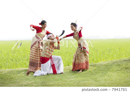 Bihu man playing on a pepa while Bihu women dance to his tune 7941781