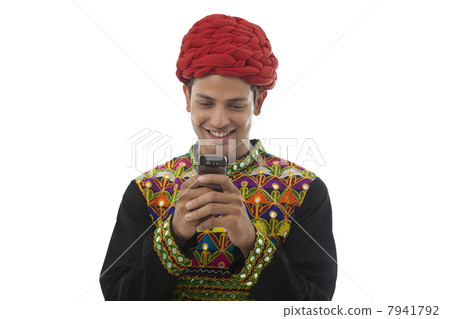 Male dandiya dancer reading an sms Male dandiya dancer reading an sms 7941792