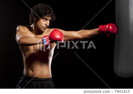 Handsome young man hitting punching bag 7941815