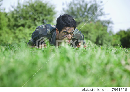 Young soldier crawling on field 7941818