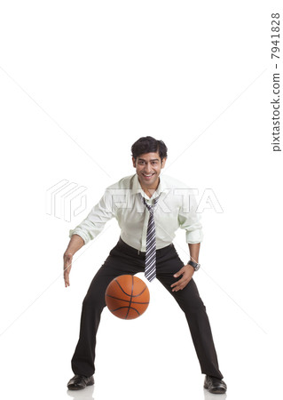 Portrait of young businessman playing basketball 7941828