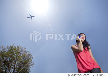 Low angle view of woman having conversation on cell phone 7941850
