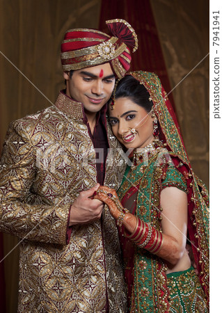 Portrait of bride resting her head on mans shoulder while holding hands 7941941