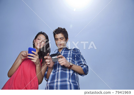 Smiling couple busy with their cell phones 7941969