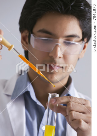Confident male scientist adding liquid to the test tube Confident male scientist adding liquid to the test tube 7941970
