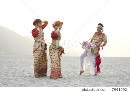 Bihu women dancing as Bihu man plays on a dhol Bihu women dancing as Bihu man plays on a dhol 7941992