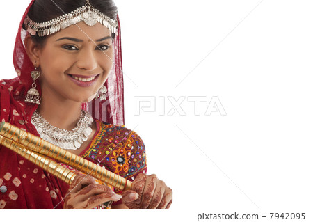 Portrait of a female dandiya dancer with sticks 7942095