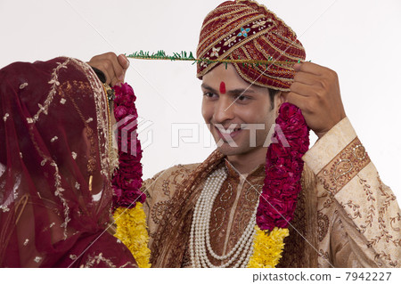 Gujarati groom putting a garland on a bride Gujarati groom putting a garland on a bride 7942227