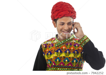 Male dandiya dancer talking on a mobile phone 7942252