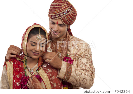 Gujarati groom tying a mangal sutra around brides neck 7942264