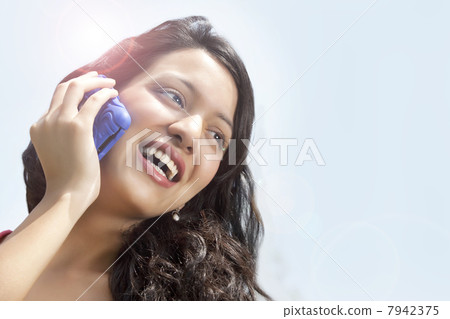 Close-up of cheerful woman having conversation on mobile phone 7942375