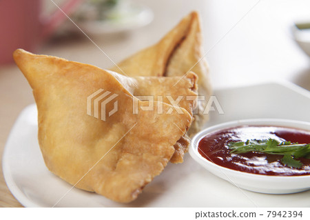 Close-up of plate of samosa with tomato sauce 7942394