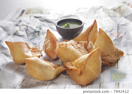 Close-up of samosas on a piece paper with chutney 7942412