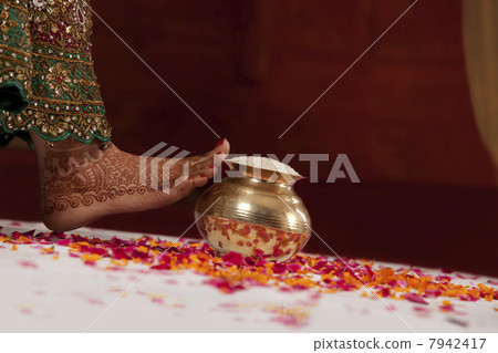 Close-up of womans leg and vase filled with rice 7942417