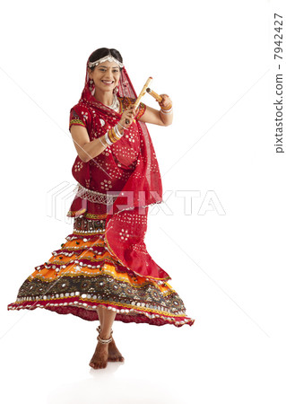 Female dandiya dancer dancing with sticks 7942427