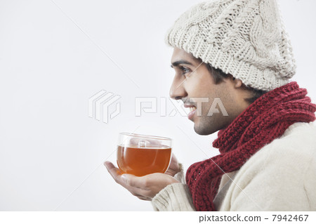 Young man holding tea cup over white background Young man holding tea cup over white background 7942467