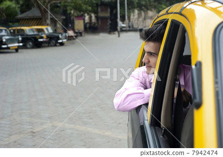 Businessman looking out of a taxi Businessman looking out of a taxi 7942474