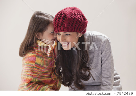 Girl whispering in mothers ear 7942489