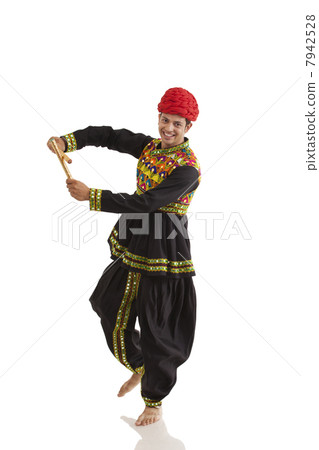 Male dandiya dancer dancing with sticks 7942528