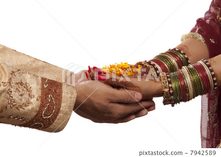 Close-up of bride and grooms hands with marigold 7942589