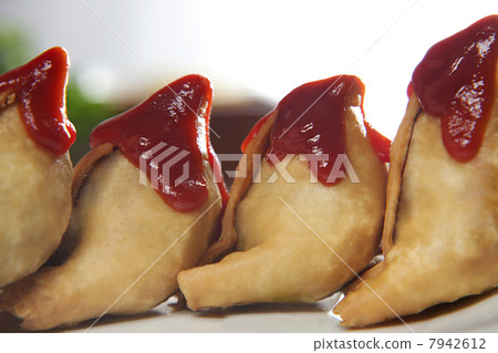 Close-up of tomato ketchup on top of samosas kept in row Close-up of tomato ketchup on top of samosas kept in row 7942612