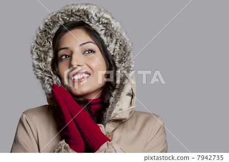 Happy young woman on winter clothes looking away 7942735