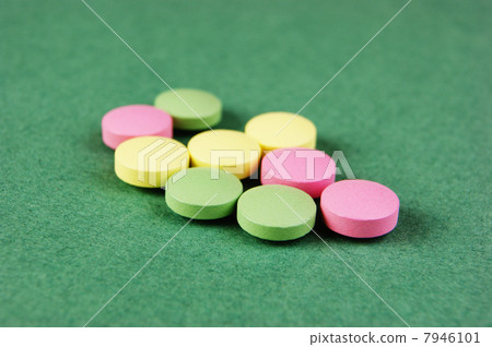 Pills and tablets on a green background Pills and tablets on a green background 7946101