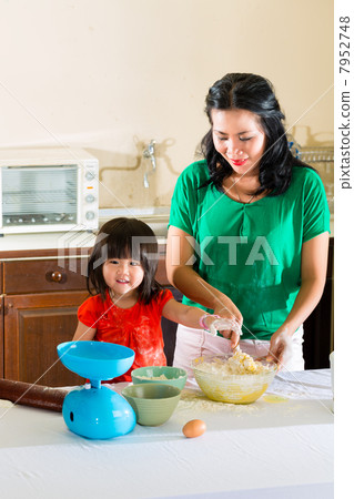 Asian Mother and daughter at home in kitchen 7952748