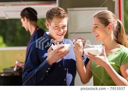 Friends eating a soup on the food stall Friends eating a soup on the food stall 7953037