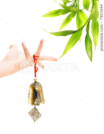 Hand holding golden bell and bamboo plant in the corner Hand holding golden bell and bamboo plant in the corner 7955044