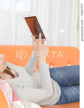 A young woman operating a tablet PC 7964707