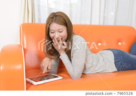 A young woman operating a tablet PC 7965526