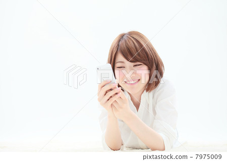 使用智能手機的婦女,當躺下時 使用智能手機的婦女,當躺下時 7975009