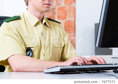 Police Officer working on desk in department 7977571