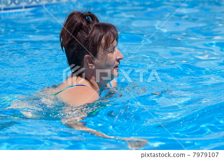 Middle-aged woman swims in the swimming pool 7979107