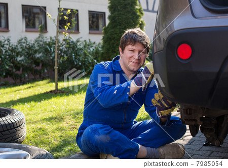 Young man changing wheel on car 7985054