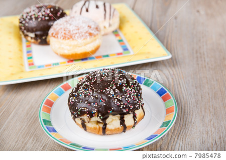 Chocolate and coconut donuts with carnival decoration. 7985478