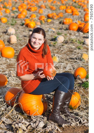 Young woman working on pumpkin field 7985490
