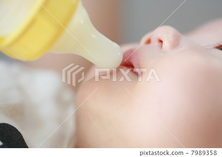Baby drinking breast milk in a feeding bottle Baby drinking breast milk in a feeding bottle 7989358