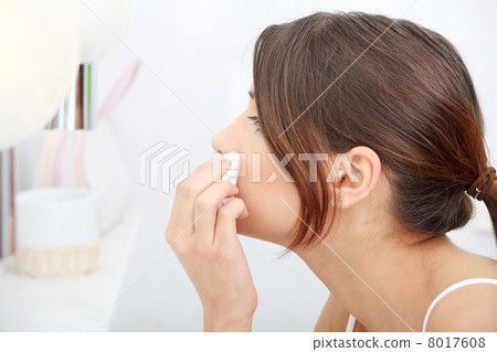 Young beautiful caucasian woman cleaning her face Young beautiful caucasian woman cleaning her face 8017608