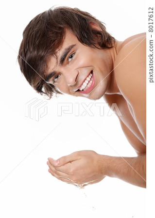 Young handsome man washing his face 8017612