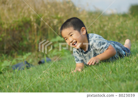 有爬行在草的微笑的一個男孩 8023039