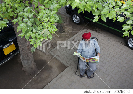 Sikh taxi driver reading the newspaper 8026063