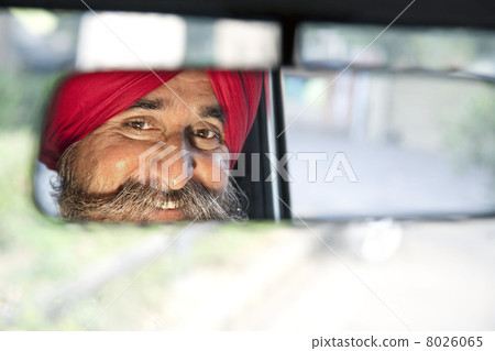 Sikh taxi driver looking into the rear view mirror 8026065
