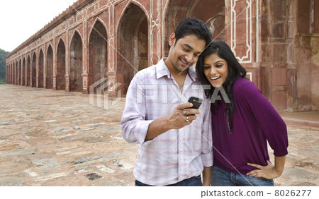 Couple reading an sms at Humayuns Tomb 8026277